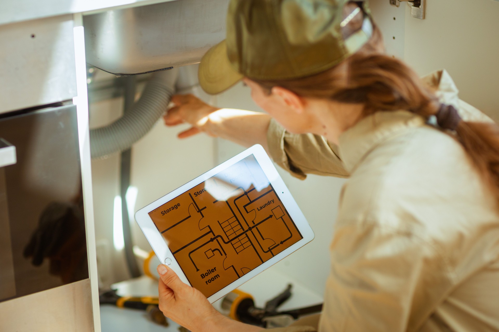 professional Inspecting Plumbing With Tablet