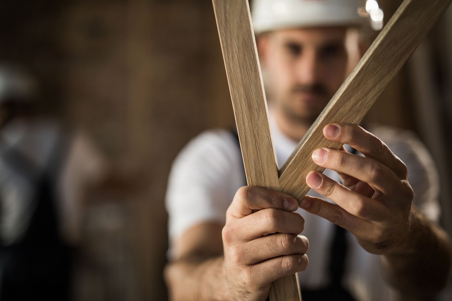 Close up of manual worker adjusting wood planks on a construction site.